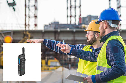 Coworkers at construction site with radio device